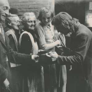 876760 Afbeelding van enkele wachtende mensen bij de voedseluitdeling uit de gaarkeuken gerund door de Zusters ...